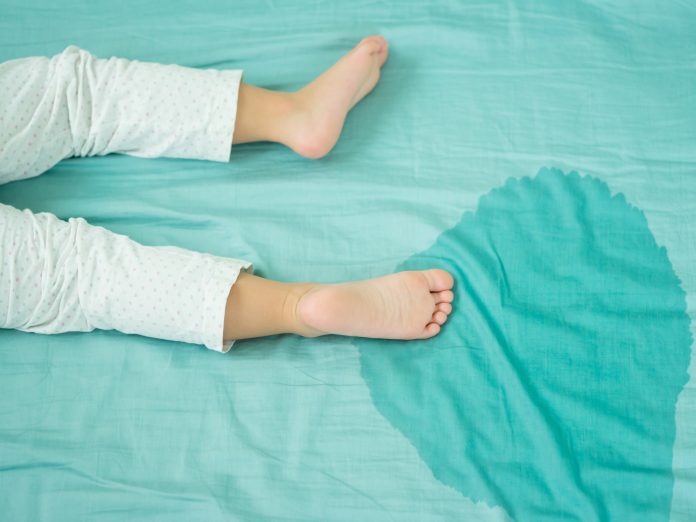 Kid's feet and pee in a mattress.Little girl feet and pee in bed sheet on the morning.Child development concept.