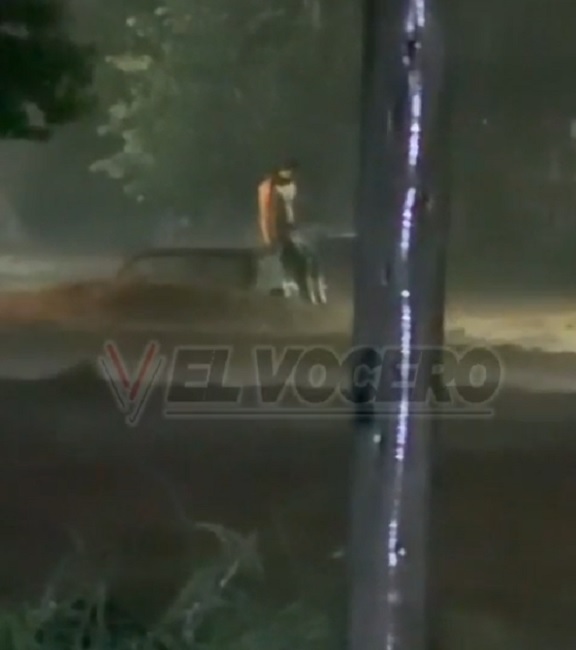 hombre sobre el auto en la corriente